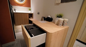 Una kitchenette compacta con estufa integrada, un lavamanos pequeño y una encimera.