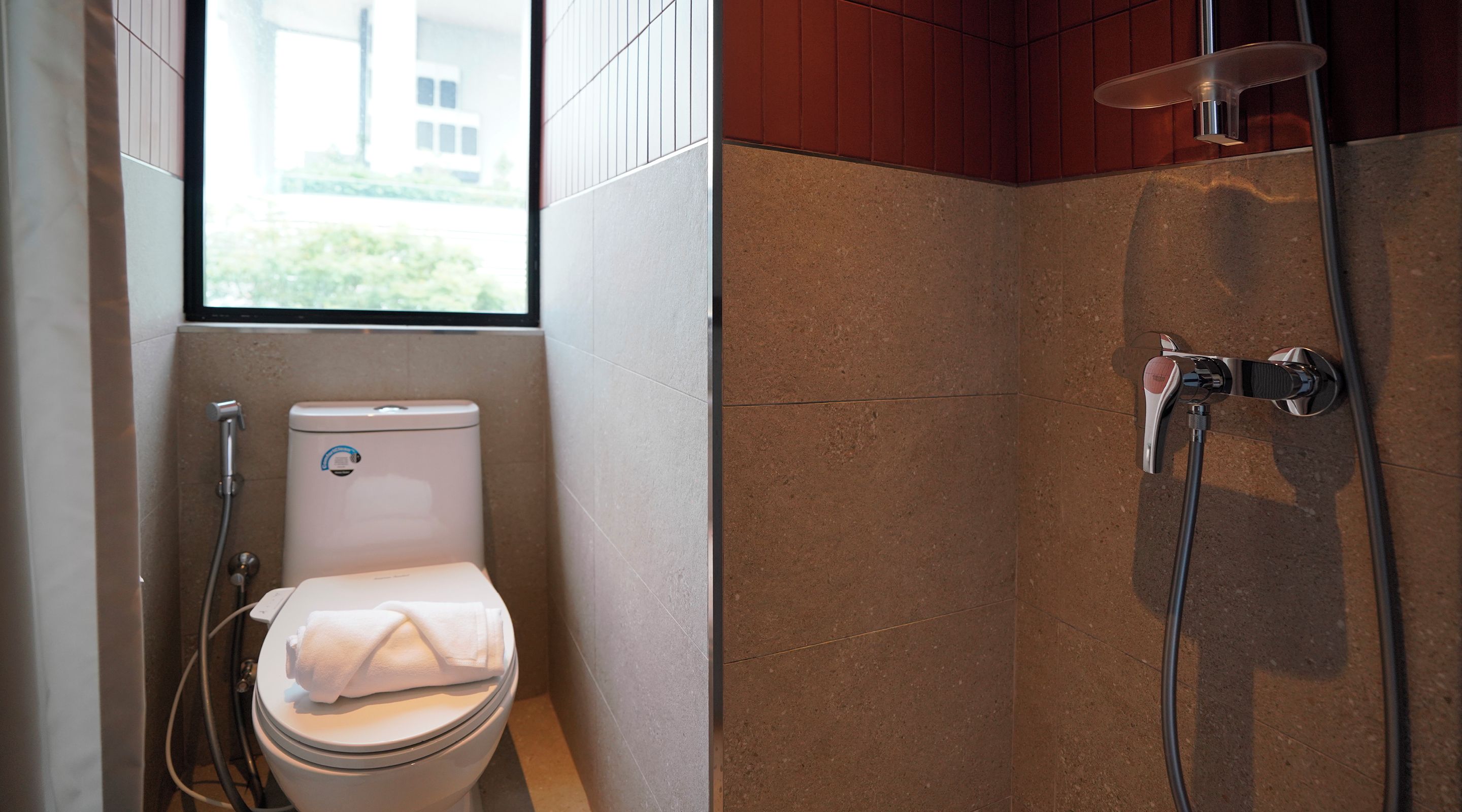 Un baño moderno con inodoro, ducha y ventana.