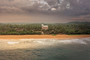Un hotel frente al mar con vistas al océano y palmeras.
