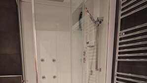 A modern bathroom with a glass-enclosed shower, a white sink, and a towel rack. - Vrbo Property (Bari)