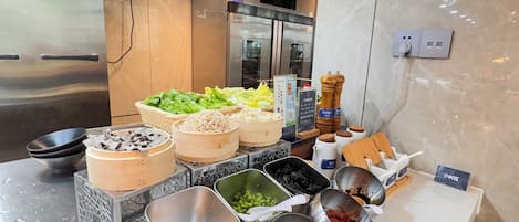 A buffet setup with various food items and condiments.