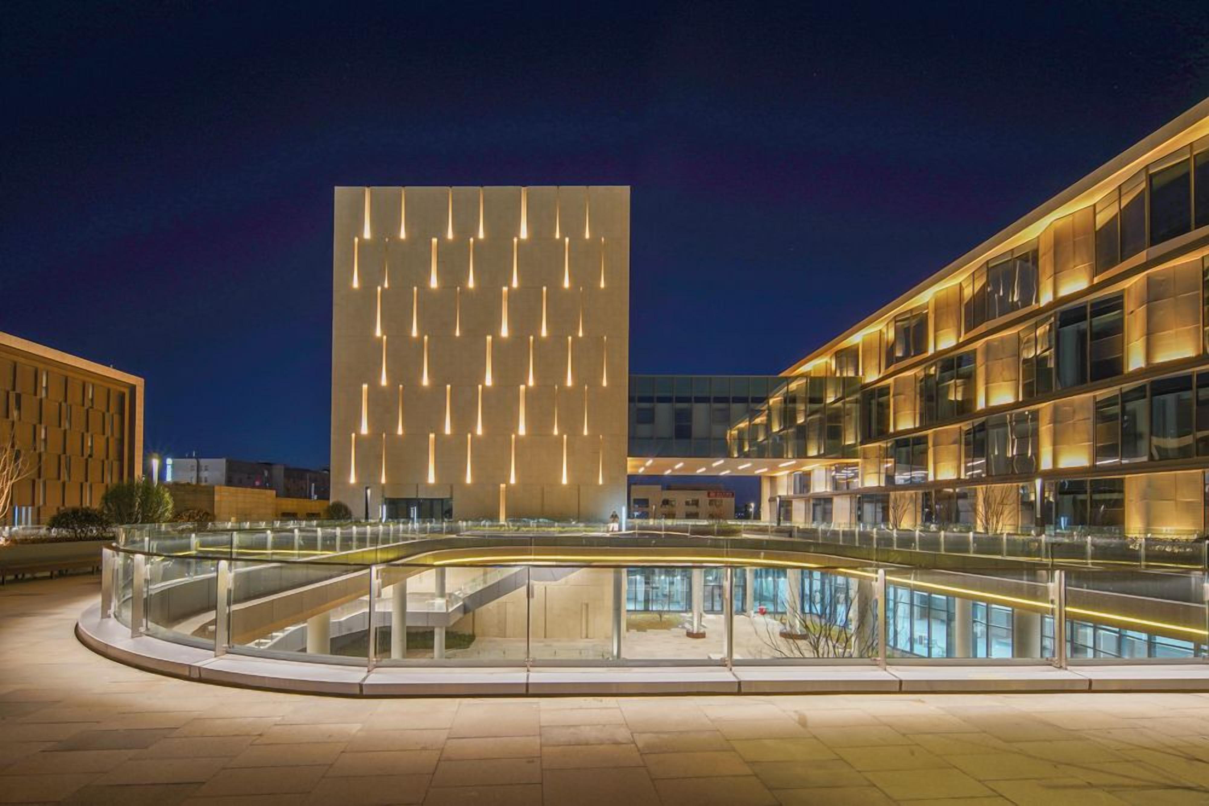 Un edificio moderno con una fachada singular que incluye luminarias verticales.