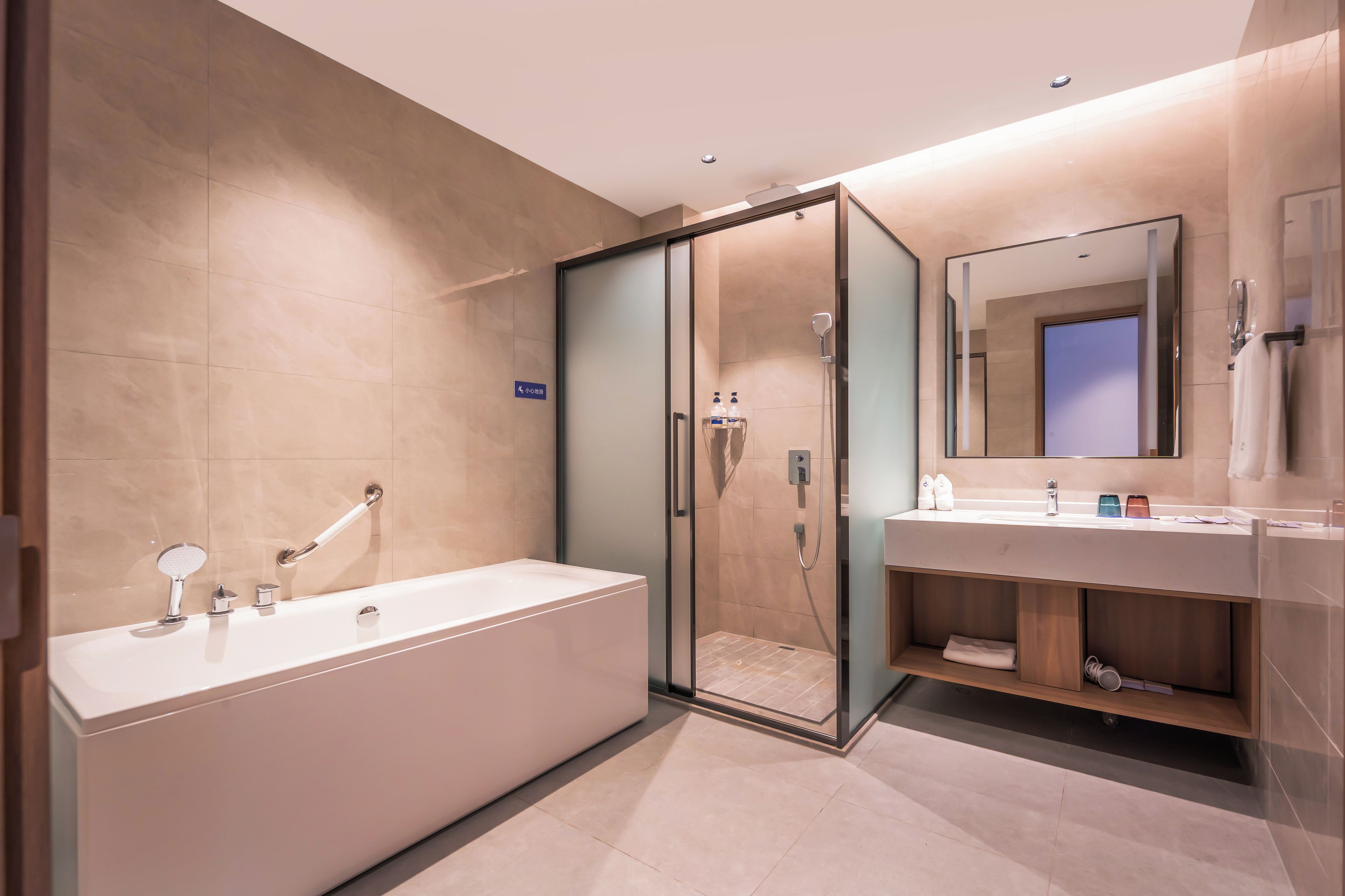 A modern bathroom with a walk-in shower, a separate bathtub, and a vanity with a mirror.