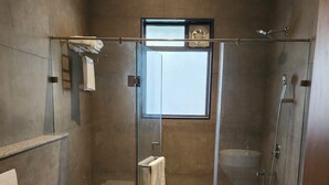 Un bagno moderno con doccia vetro, un water, un lavandino e un grande specchio.