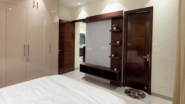 Une chambre à coucher comprenant un lit, une armoire et un meuble pour la télévision intégré.