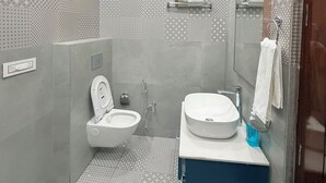 Une salle de bain moderne équipée de toilettes, d’un bidet et d’un lavabo.