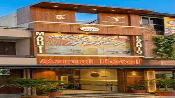 Un hotel con un letrero llamativo que dice 'Maruti Hotel' y 'FASHO' en la fachada.