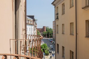 A street view from a balcony with buildings on either side, a clear sky, and parked cars. - Finestra sulle Porte Palatine by Wonderful Italy (Torino)