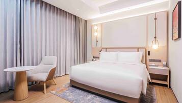 Una habitación de hotel con una cama, una silla, una mesa y una mesita de noche.