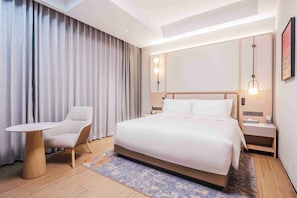 A hotel room with a bed, a chair, a table, and a nightstand. - ALSO HOTEL Shanghai (Shanghai)