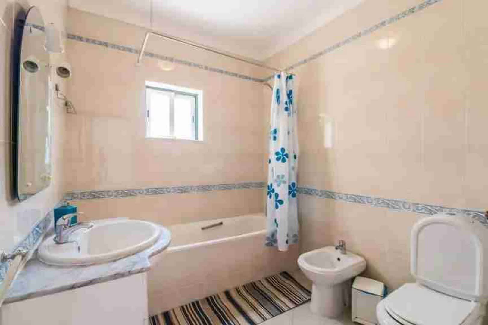 A bathroom with a bathtub, a toilet, and a sink.
