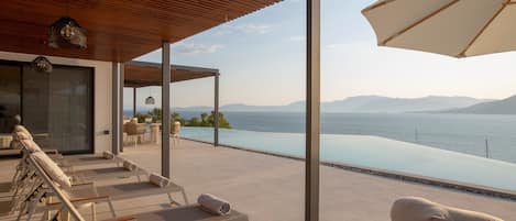 Un área de descanso moderna al aire libre con sillones y vistas a una gran masa de agua.