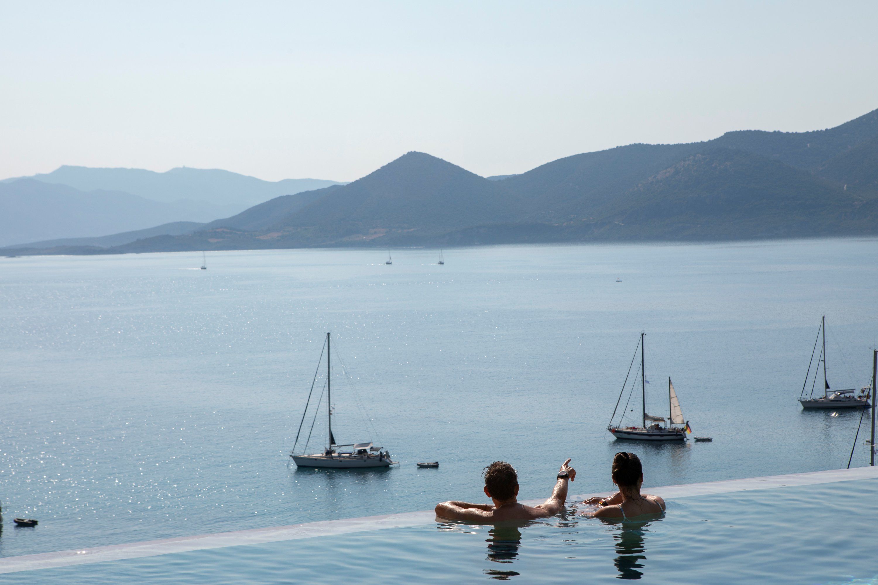 Une piscine avec vue sur la mer et les bateaux.