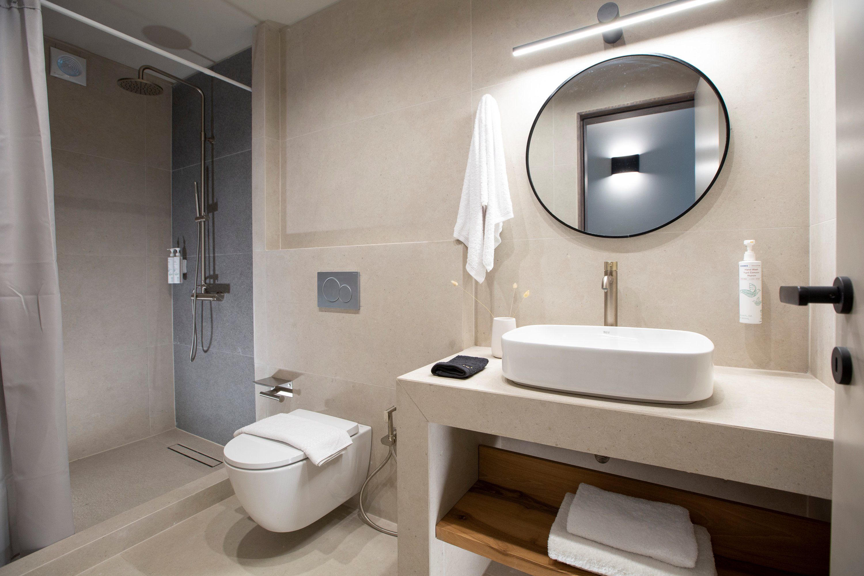 A modern bathroom with a toilet, sink, and shower.
