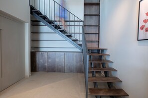 A staircase with a metal railing and wooden steps leading to a landing.