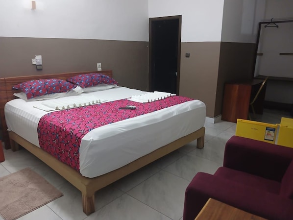 Una habitación de hotel con una cama, un escritorio y una silla.