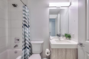 Une salle de bain moderne équipée d’une douche, de toilettes et d’un lavabo.