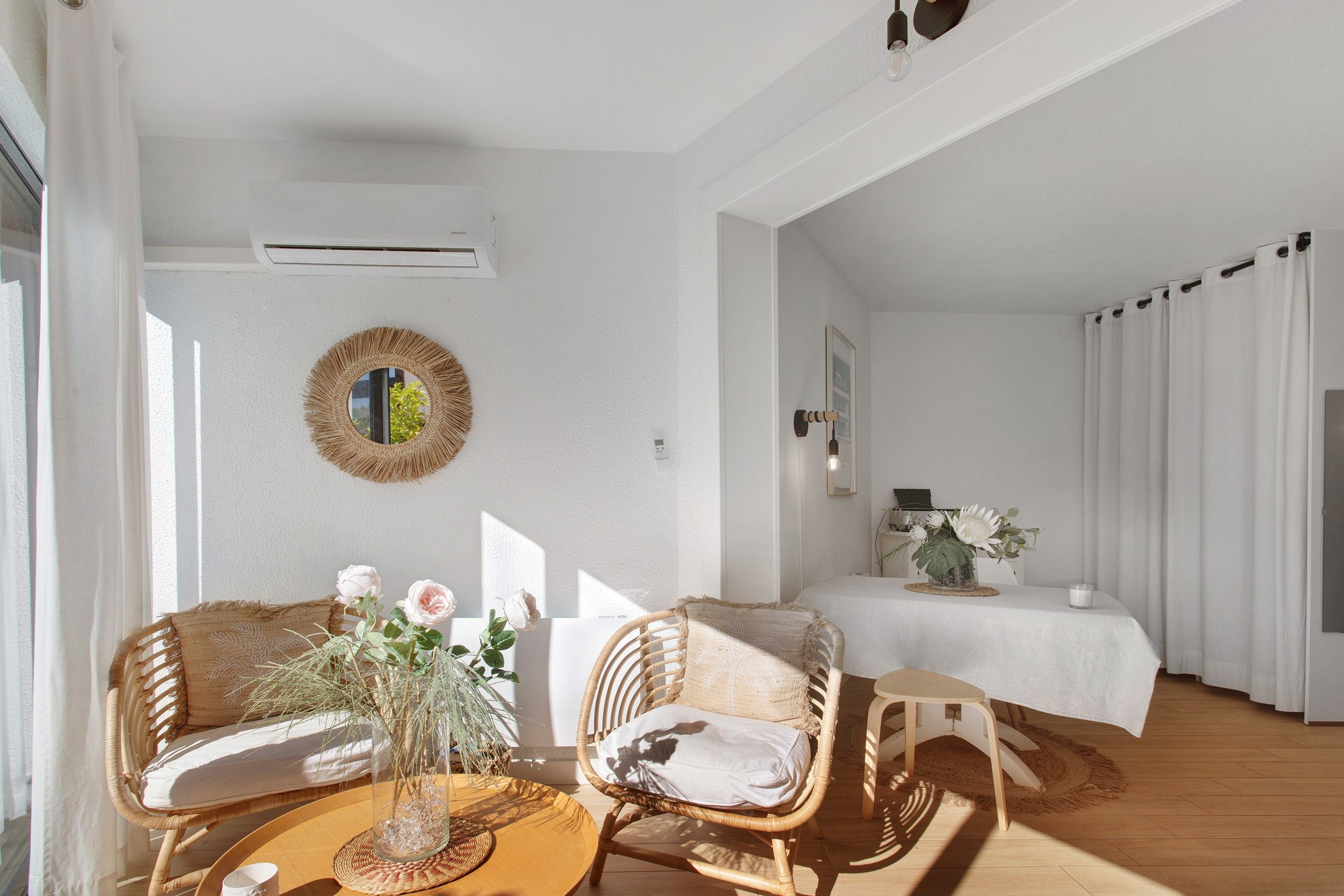 Ein Zimmer mit einer Couch, Sesseln, einem Tisch und einem Bett.