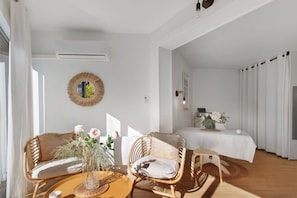 Una habitación con sofá, sillas, una mesa y una cama.