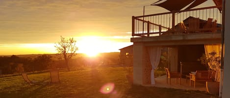 A house with a balcony overlooking a sunset.