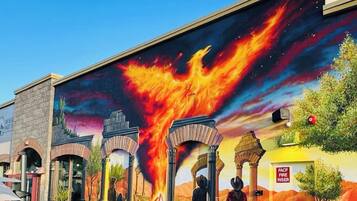 Un mural con un fénix llameante, arcos y un paisaje desértico.