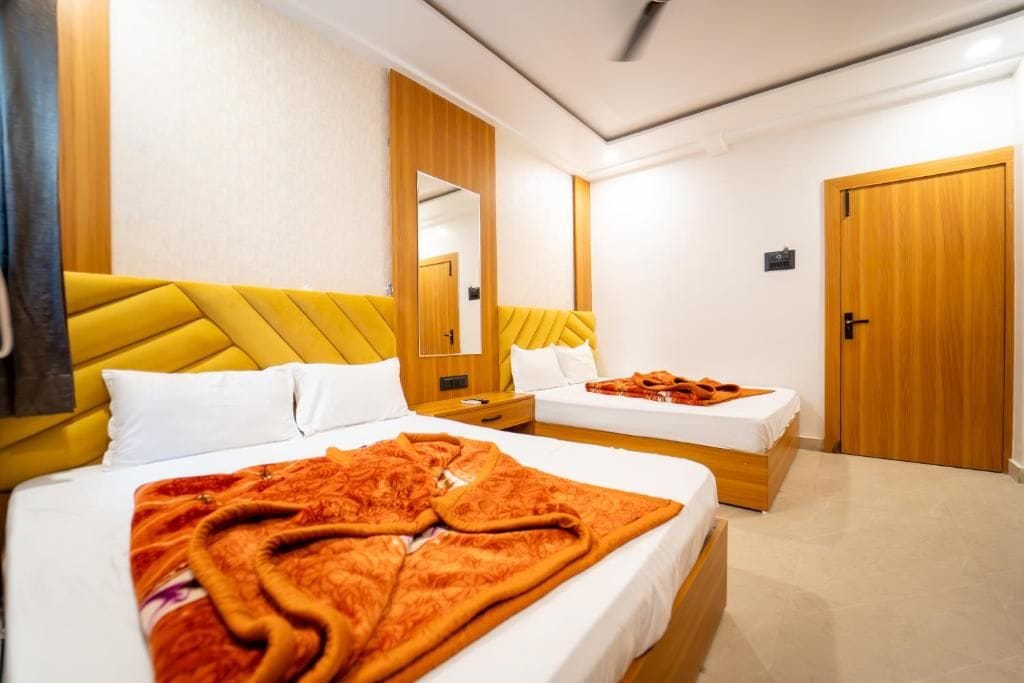 Habitación de hotel con dos camas, un espejo grande y un armario de madera.