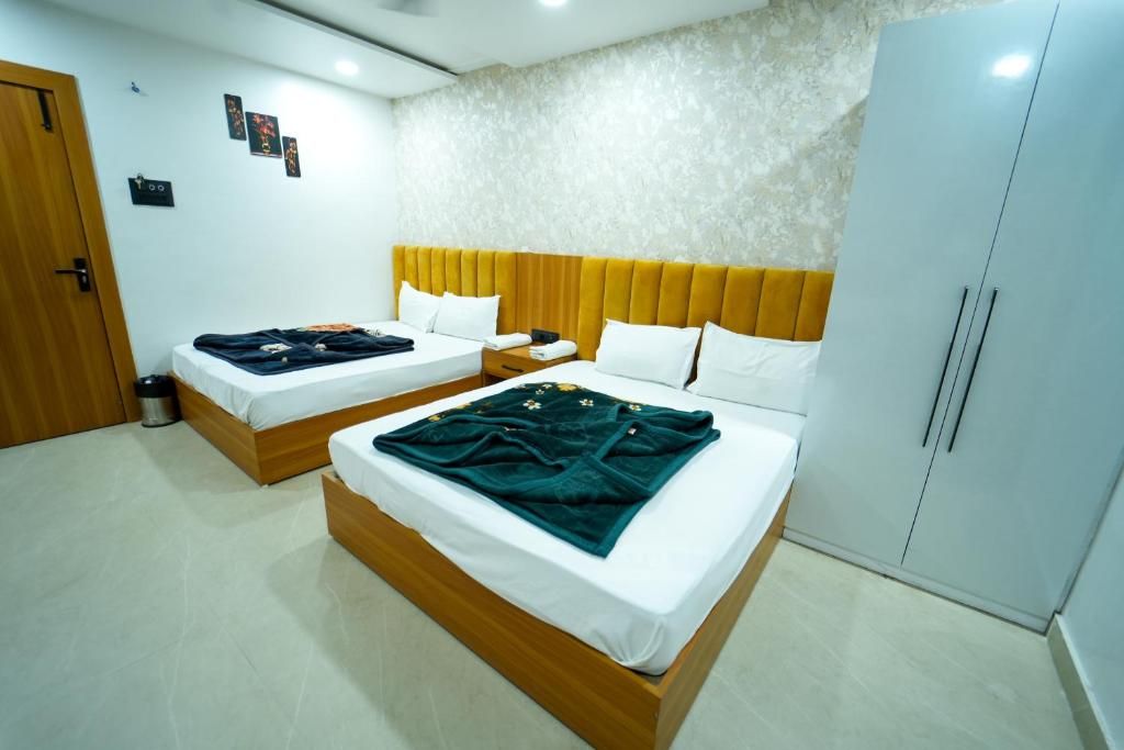 Una habitación de hotel con dos camas, un armario y una mesita de noche.