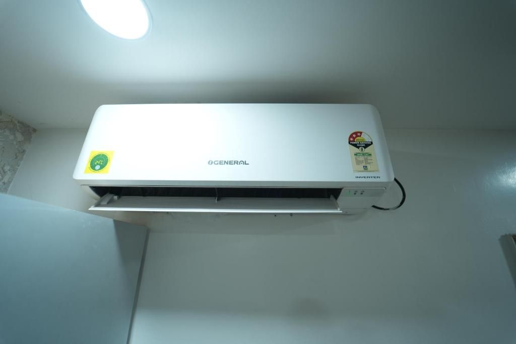 Un equipo de aire acondicionado blanco montado en la pared, con un panel de control a la derecha.