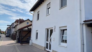 Un immeuble résidentiel doté d’une allée dallée, d’un garage et surplombant un ciel dégagé.