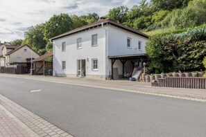 A two-story building with a flat roof and a covered porch area. - Apartment 'Unterhaun' with Private Garden and Wi-Fi (Hauneck)