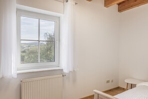 A room with a window, radiator, and a small table.