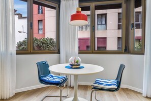 A small room with two chairs, a table, and a red lamp. - Home2Book El Faro by Las Canteras Beach (Las Palmas de Gran Canaria)