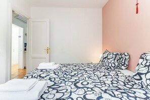 A bedroom with a bed, a door, and a wall with a red tassel. - Home2Book Los Tunos Bungalow & Pool, Maspalomas (Maspalomas)