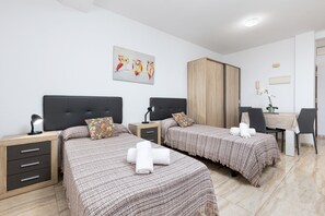 A hotel room with two beds, a desk, a wardrobe, and a painting on the wall. - Home2Book Betty´s City Studio Rooftop Views (Puerto del Rosario)