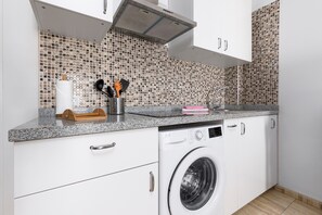 A kitchen with a washing machine, a tiled backsplash, and white cabinets. - Home2Book Betty´s City Studio Rooftop Views (Puerto del Rosario)