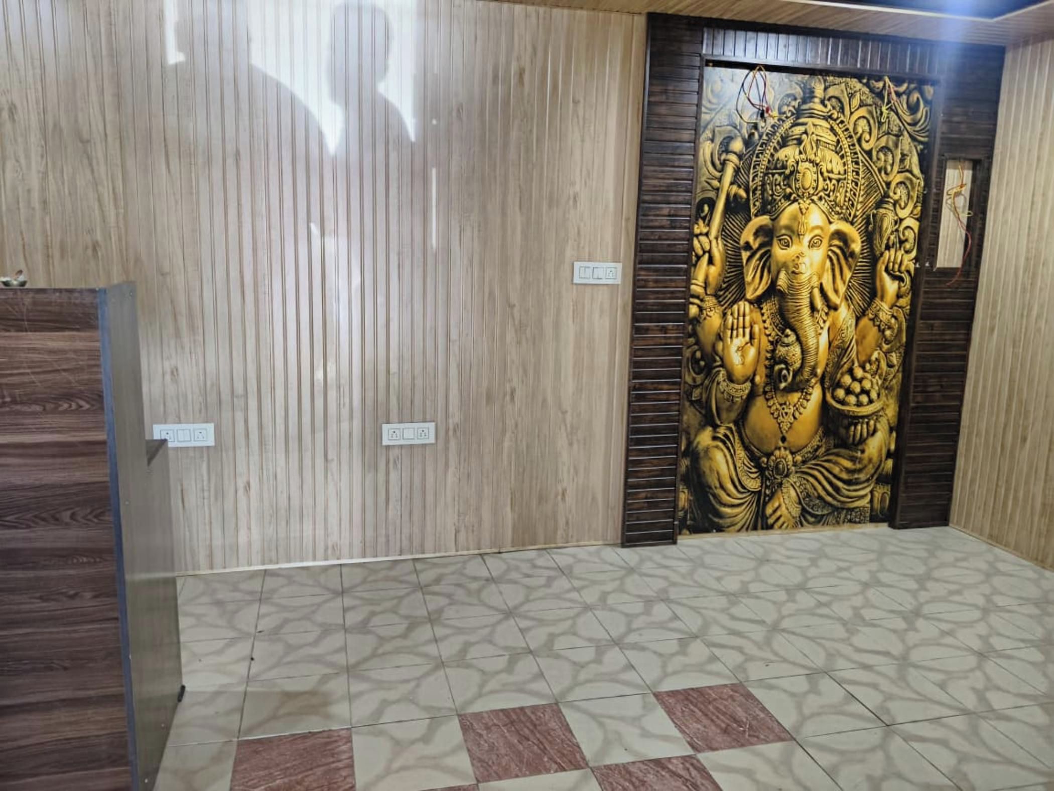 A room with a patterned floor, a wooden door, and a wall with a relief sculpture.