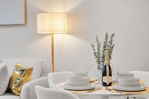 A dining table set with white plates, glasses, and a bottle of champagne. - Luxury 2BR in the Heart of Melbourne CBD + Gym (Melbourne)
