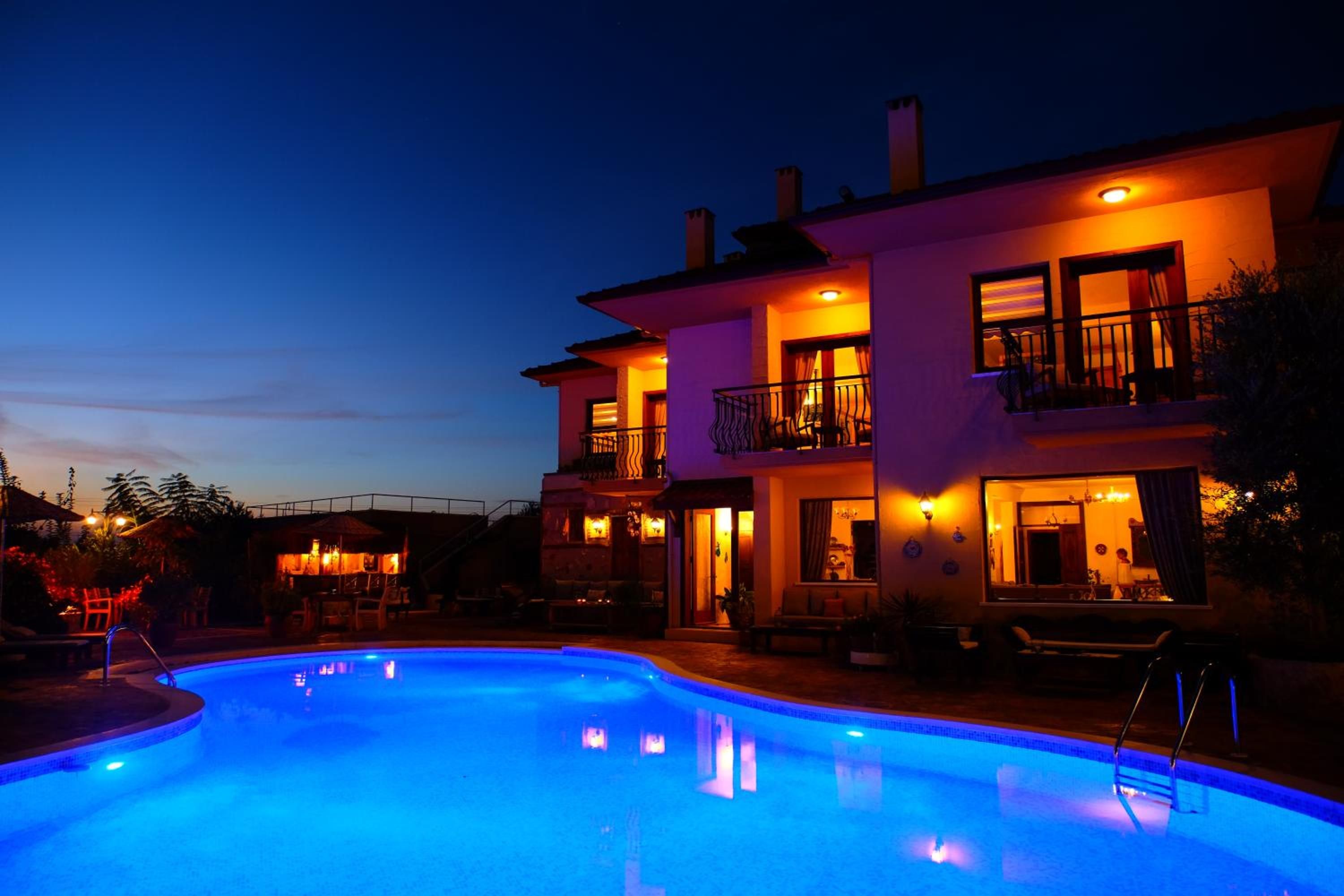 A two-story building with a swimming pool, outdoor seating, and a bar area.