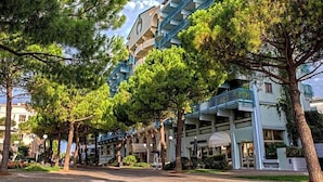 A hotel with a modern architectural design, featuring a prominent staircase and multiple balconies. - Hotel Astoria (Grado)