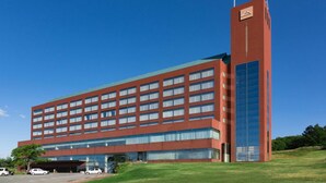 A multi-story building with a prominent vertical tower, large windows, and a flat roof. - Rockwood Hotel and Spa (Ajigasawa)