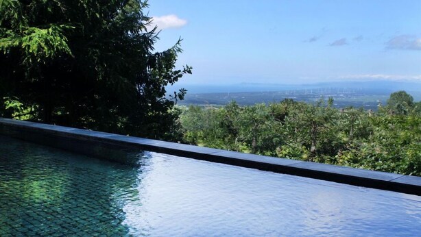 A swimming pool with a view of a cityscape and greenery. - Rockwood Hotel and Spa (Ajigasawa)