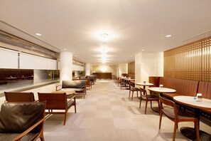 A modern interior with a checkered floor, wooden furniture, and a central seating area. - Rockwood Hotel and Spa (Ajigasawa)