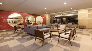 A hotel lobby with a checkered floor, a seating area with sofas and chairs, and a visible restaurant in the background. - Rockwood Hotel and Spa (Ajigasawa)