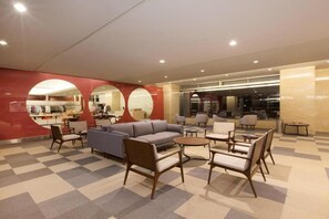 A hotel lobby with a checkered floor, a seating area with sofas and chairs, and a visible restaurant in the background. - Rockwood Hotel and Spa (Ajigasawa)