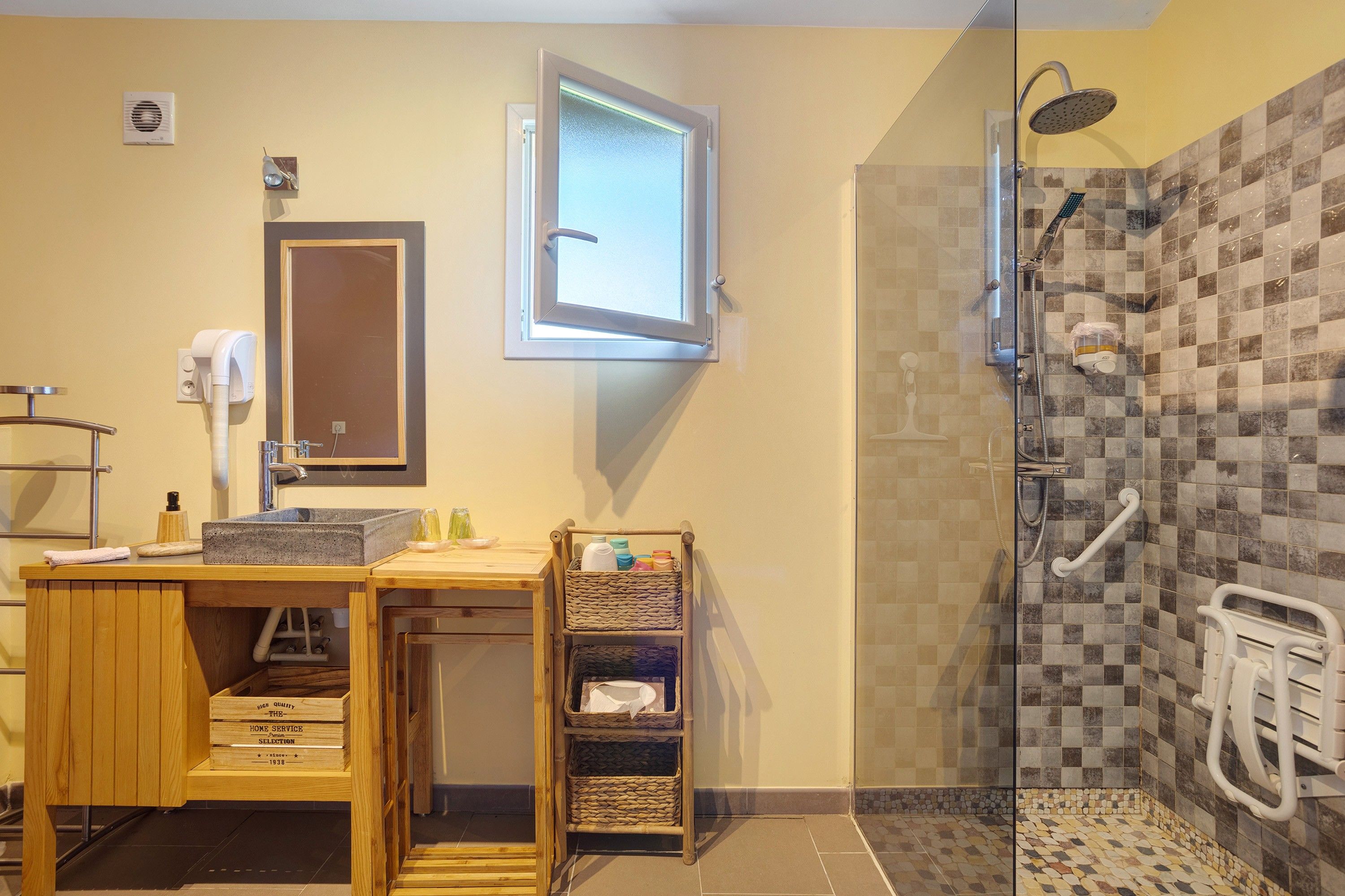 Een badkamer met een douche, een wastafel, een spiegel en een handdoekhouder.