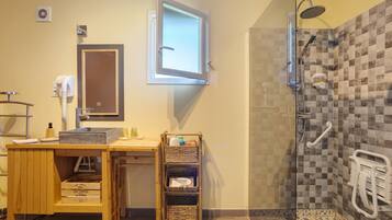 Een badkamer met een douche, een wastafel, een spiegel en een handdoekhouder.