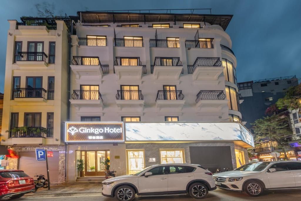 Monikerroksinen hotelli, jossa on parvekkeet, pysäköintikyltti ja kyltti, jossa lukee ”Ginkgo Hotel”.