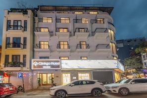 A multi-story hotel with balconies, a parking sign, and a sign for the Ginkgo Hotel. - Ginkgo Hotel Hanoi (Hanoi)