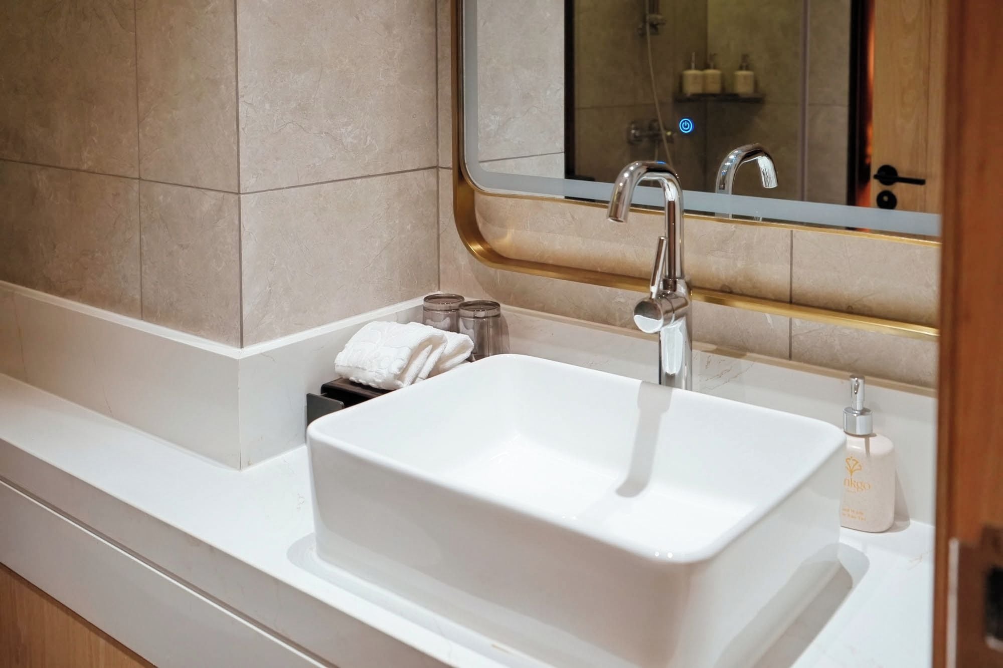 Une salle de bain avec un lavabo blanc, un miroir et un espace douche.