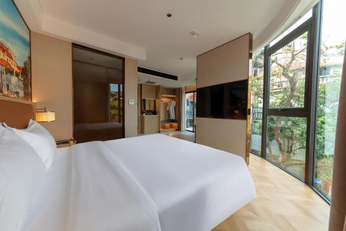 Una camera d'albergo con un letto grande, una televisione e vista sull'esterno.